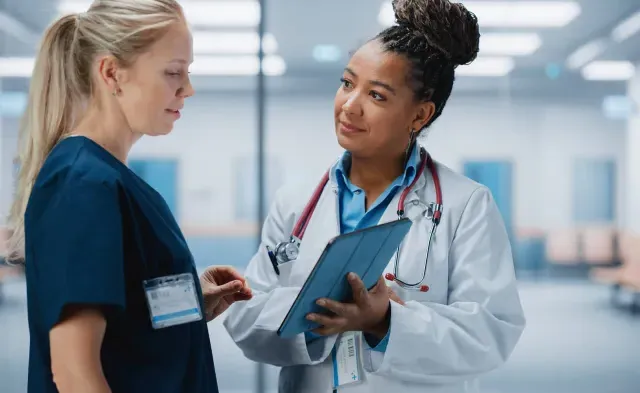 Nurse Practitioner Showing Patient Chart to Registered Nurse